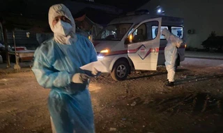 Các quan chức y tế và một xe cấp cứu chờ đợi để thu thập các bệnh nhân COVID-19. (Rasmei News)