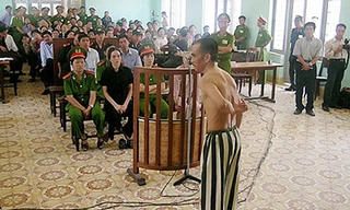 Ông Huỳnh Văn Nén cởi áo tại phiên tòa xử vụ án “vườn điều” để mô tả bị điều tra viên dùng nhục hình và ép cung. Ảnh: PHƯƠNG NAM