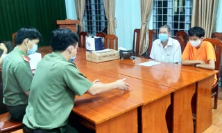 P.T (áo cam) tại cơ quan công an. Ảnh: CACC