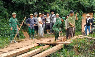 Chiến sĩ quân hàm xanh hỗ trợ người dân dựng lại cầu gỗ bị lũ cuốn