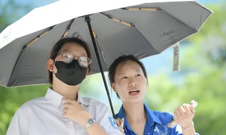 Sinh viên ĐH Thương mại đội nắng hỗ trợ thí sinh làm thủ tục thi tại điểm thi THCS Yên Hòa