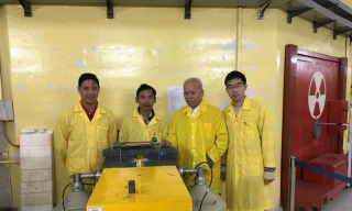 GS Phạm Duy Hiển (thứ hai từ phải) với các nhà khoa học trẻ trước cửa kênh dẫn nơtron lò phản ứng Đà Lạt.