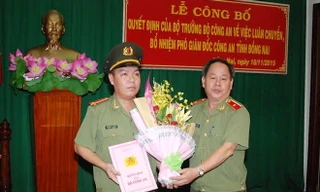 Thiếu tướng Nguyễn Thanh Nam (bìa phải) trao quyết định và tặng hoa chúc mừng Trung tá Lê Hoàng Ngân. Ảnh: Báo Đồng Nai 