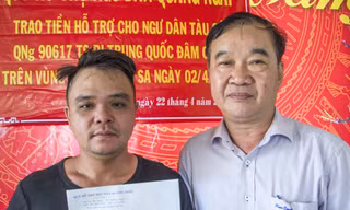 Ông Phan Huy Hoàng, Giám đốc Quỹ hỗ trợ ngư dân Quảng Ngãi trao tiền hỗ trợ cho thuyền trưởng Trần Hồng Thọ - ảnh V.C 