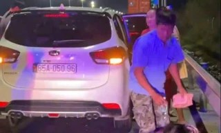 Dừng xe trên cao tốc, ngồi bệt dưới đường bày biện đồ ăn để ăn tối