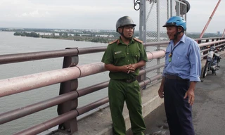 Đại uý Nguyễn Minh Nhựt nói chuyện với bảo vệ cầu Cần Thơ về việc giữ gìn an ninh trật tự trên cầu.