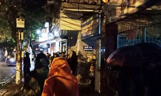 Một số người dân đội mưa lúc 23 giờ đêm ngày 6/4 để ngóng xem việc nhà ông Phan Văn Vĩnh.