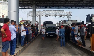 Nhiều tài xế ra khỏi xe đứng chờ trạm giải quyết. Ảnh: Nhật Huy.