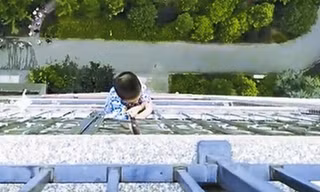 Bé trai trượt chân ngã và treo lơ lửng bên ngoài ban công tầng 19 hơn nửa giờ. Ảnh: dzrbs.com.