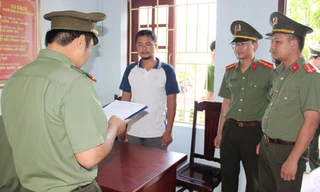 Công an đọc lệnh bắt nghi can Nguyễn Duy Sơn. Ảnh: Lam Sơn.