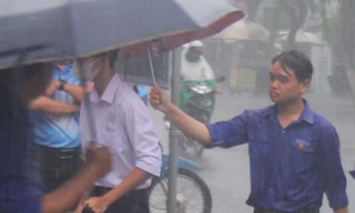 Tình nguyện viên dầm mưa hỗ trợ thí sinh 