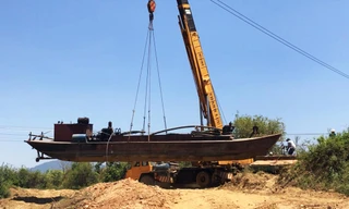 Lực lượng chức năng cẩu phương tiện khai thác cát trái phép về nơi tạm giữ