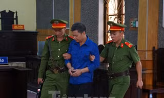 Bị can Lò Văn Huynh (ở giữa) thay đổi lời khai, nói không nhận tiền từ cựu sĩ quan công an. Ảnh: X.A