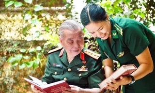 Thiếu tá, nhà văn Phạm Vân Anh xin ý kiến Đại tướng Nguyễn Quyết về những cứ liệu lịch sử cho tập bút ký. Ảnh: Việt Văn