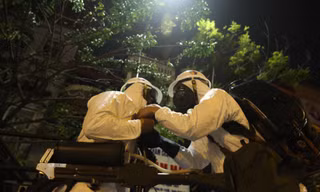 Bộ đội Hóa học phun khử khuẩn bên ngoài khoa A1, Bệnh viện Bạch Mai, tối 28/3. Ảnh: Nguyễn Minh