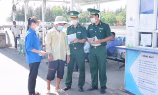 Cán bộ Đồn Biên phòng Cần Thạnh phát tờ roi tuyên truyền cho người dân trên địa bàn, sau lễ phát động