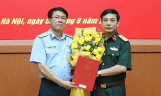 Thừa ủy quyền của Chủ tịch nước Nguyễn Xuân Phúc, Đại tướng Phan Văn Giang, Phó Bí thư Quân ủy Trung ương, Bộ trưởng Bộ Quốc phòng trao quyết định thăng quân hàm từ Thiếu tướng lên Trung tướng cho Quyền Tư lệnh Vũ Văn Kha (bên trái ảnh).