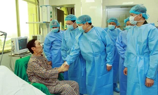 Đại tướng Ngô Xuân Lịch thăm hỏi, trò chuyện với ông Trần Ngọc Hanh - người được ghép phổi lấy từ người cho chết não đầu tiên ở Việt Nam tại Bệnh viện T.Ư Quân đội 108, sáng 27/3 