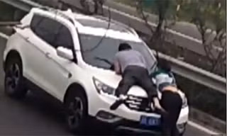 Cô gái và người yêu mới không ngại đu bám ca pô đòi tiền dù có thể nguy hiểm tới tính mạng. Ảnh cắt từ clip.