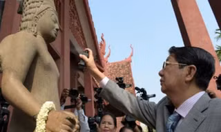 Phó Thủ tướng Campuchia Sok An xịt nước hoa lên pho tượng thần Harihara trong buổi lễ nối đầu và thân tượng ở Bảo tàng Quốc gia tại Phnom Penh. Ảnh: CNN