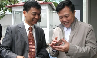 Ông Nguyễn Văn Quyền (phải) chúc mừng anh Cường, người đầu tiên nhận GPLX qua khai báo điện tử.