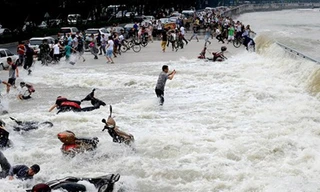 Trong khi người người bỏ chạy, xe cộ bị cuốn trôi thì anh chàng này vẫn "sống chết mặc bay". 