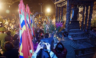 Người đi lễ lao vào cướp hoa, lộc mặc ban tổ chức đang thu dọn đồ lễ. Ảnh: Giang Huy.