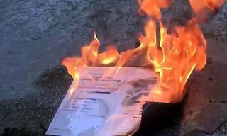 Bằng tốt nghiệp đại học bị đốt. Ảnh cắt từ clip.