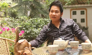 Trọng Tấn bên cạnh một trong ba con mèo đang được anh nuôi ở nhà. Ảnh: Quang Đức.