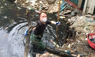 Hình ảnh "ông Tây" mặc quần nilon, đeo khẩu trang "đằm" mình dưới cống bẩn để dọn rác thải được nhiều người chia sẻ trên mạng xã hội