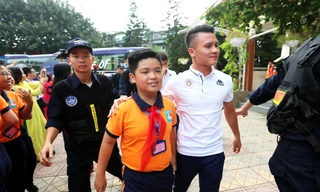 Quang Hải vui vẻ bước vào cùng các em học sinh