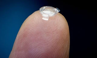 Bác sĩ Garth Webb đặt thấu kính sinh học trên ngón tay. Ảnh: Canadian Press