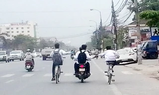 "Tổ hợp xe kéo" của 4 học sinh đang "làm xiếc" trên đường Quốc lộ 1A đoạn đi qua phường Quán Bàu (Tp Vinh, Nghệ An). 