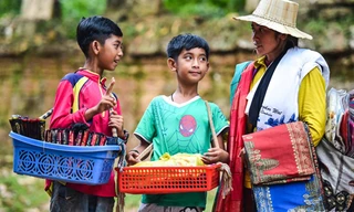 Salik (phải) cùng mẹ và em trai hàng ngày bán rong đồ lưu niệm cho khách du lịch quanh đền Ta Prohm.