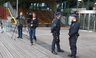 Cảnh sát và nhà báo bên ngoài Tòa án Antwerp, Bỉ