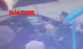 Lực lượng an ninh dẫn giải Vũ “nhôm” ra xe ô tô (ảnh cắt từ clip Báo Giao thông)