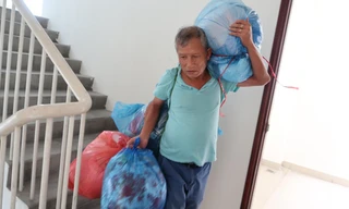 Ông Trần Quang Huệ mang hành lý ra khỏi chung cư