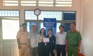 Bà Hoàng Thị Yên (thứ ba từ trái sang), Chánh văn phòng Quỹ Bảo hiểm Xe cơ giới trao hỗ trợ 20 triệu đồng cho người dân ở Đồng Tháp. Ảnh: Quỳnh Vân