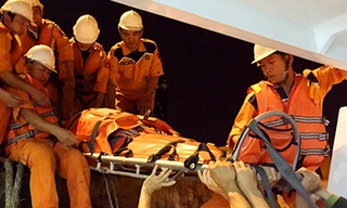 Các thuyền viên tàu SAR 412 đưa ông Ross lên bờ. Ảnh: Ngọc Trường.