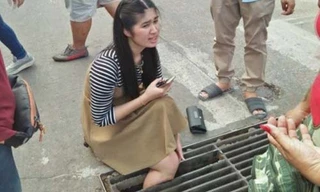 Đang đi trên đường, cô gái không may kẹt chân vào nắp cống.