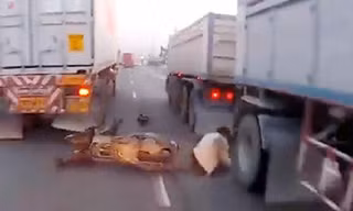Thoát chết trong gang tấc khi luồn lách qua 2 xe tải