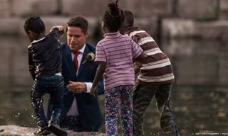 Bé trai được chú rể Clayton đưa lên bờ sau khi bị ngã xuống nước (Ảnh: BBC)