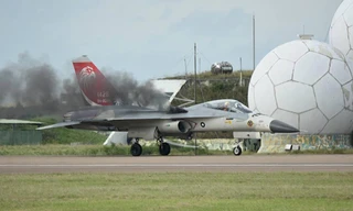 Khói đen tiếp tục bốc ra từ động cơ sau khi tiêm kích hạ cánh. Ảnh: CNA.