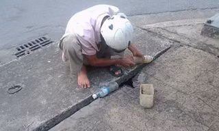 "Thợ câu” Nguyễn Quốc Minh đang “tác nghiệp” qua khe hở của miệng ống cống thoát nước trên đường Cách Mạng Tháng Tám (phường Quyết Thắng, TP.Biên Hòa, Đồng Nai).