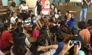 Các bạn nhỏ ngồi quây quần bên "thầy giáo nhí" Jayden.