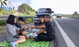 Hình ảnh cả gia đình trải bạt, ăn nhậu trên đường cao tốc Nội Bài - Lào Cai trưa 6/2.