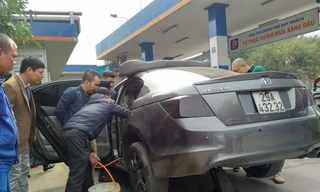 Nhân viên cây xăng rút xăng từ chiếc xe Honda Accord ra thùng. Ảnh: M.Đ
