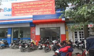 Đại diện Công ty CP Hoàng Thịnh treo băng rôn và ngồi trước cửa yêu cầu công ty Bảo hiểm Xuân Thành Thanh Hóa thanh toán tiền bảo hiểm. Ảnh: Phạm Nhài.