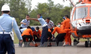 Các nhân viên cứu hộ Indonesia chuyển thi thể một nạn nhân trong vụ tai nạn máy bay QZ8501 ngày 31/12. Ảnh: AFP/TTXVN.