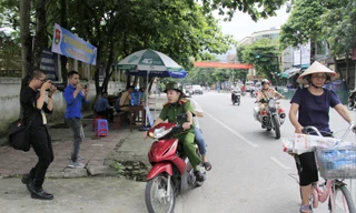 Đại úy Vũ Đức Lợi chở thí sinh Trần Thị Yến đến điểm thi, phía sau có xe chuyên dụng của CSGT hú còi hộ tống Ảnh: Trường Phong 